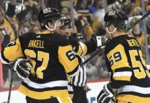Pittsburgh Penguins center Sidney Crosby (87) celebrates with Rickard Rakell (67) and Jake Guentzel (59) after a goal against the Tampa Bay Lightning during the second period of an NHL hockey game, Sunday, Feb. 26, 2023, in Pittsburgh.