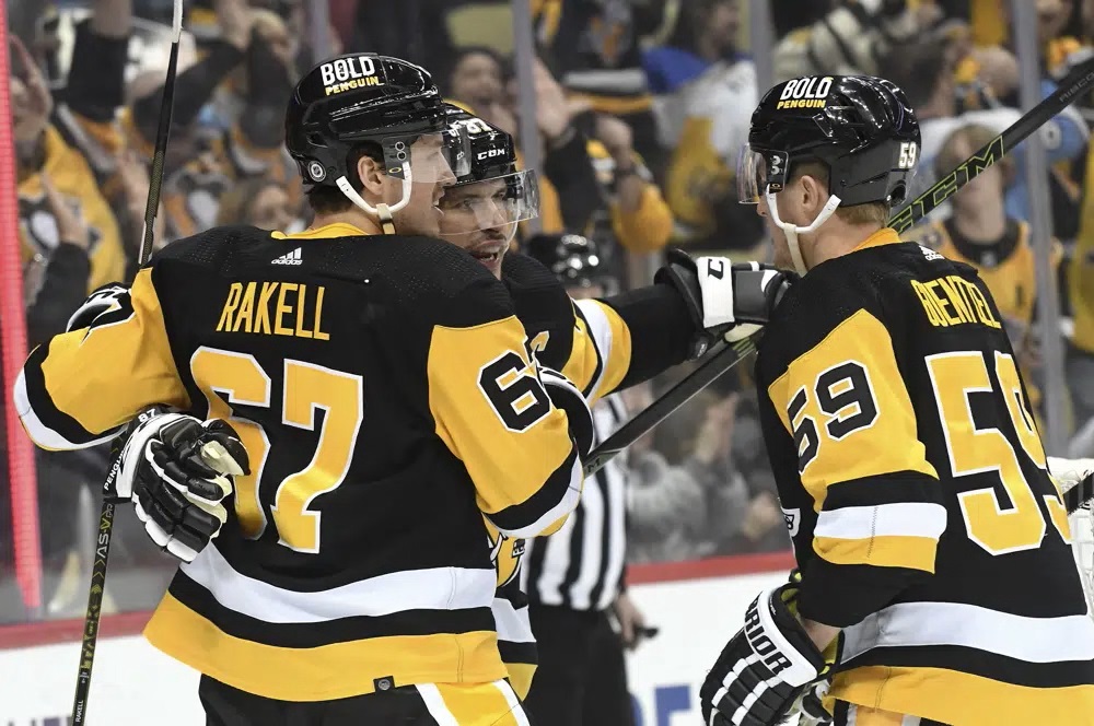 Pittsburgh Penguins center Sidney Crosby (87) celebrates with Rickard Rakell (67) and Jake Guentzel (59) after a goal against the Tampa Bay Lightning during the second period of an NHL hockey game, Sunday, Feb. 26, 2023, in Pittsburgh.