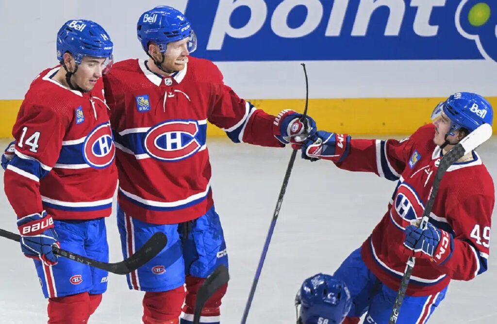 Montreal Canadiens' Mike Matheson (8) celebrates his goal against the Tampa Bay Lightning with Nick Suzuki (14) and Rafael Harvey-Pinard (49) during the second period of an NHL hockey game Tuesday, March 21, 2023, in Montreal.