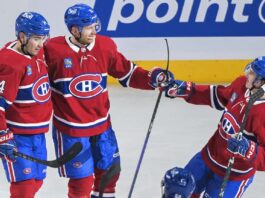 Montreal Canadiens' Mike Matheson (8) celebrates his goal against the Tampa Bay Lightning with Nick Suzuki (14) and Rafael Harvey-Pinard (49) during the second period of an NHL hockey game Tuesday, March 21, 2023, in Montreal.