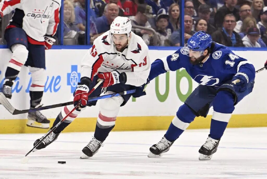 Washington Capitals right wing Tom Wilson (43) and Tampa Bay Lightning left wing Pat Maroon (14) battle for the puck during the first period of an NHL hockey game Thursday, March 30, 2023, in Tampa, Fla.