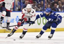 Washington Capitals right wing Tom Wilson (43) and Tampa Bay Lightning left wing Pat Maroon (14) battle for the puck during the first period of an NHL hockey game Thursday, March 30, 2023, in Tampa, Fla.