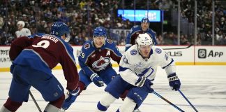 Tampa Bay Lightning center Brayden Point, right, drives witht he puck past Colorado Avalanche defenseman Cale Makar, front left, and center Nathan MacKinnon in the second period of an NHL hockey game Wednesday, Oct. 30, 2024, in Denver. (AP Photo/David Zalubowski)