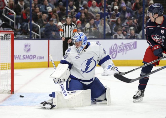 Columbus Blue Jackets forward Dmitri Voronkov, right, watches a goal by teammate Zach Werenski (not shown) get past Tampa Bay Lightning goalie Jonas Johansson, left, during the second period of an NHL hockey game in Columbus, Ohio, Thursday, Nov. 21, 2024. (AP Photo/Paul Vernon)