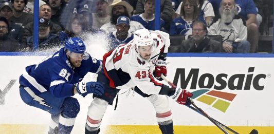 Tampa Bay Lightning defenseman Erik Cernak (81) and Washington Capitals right wing Tom Wilson battle for the puck during the second period of an NHL hockey game, Wednesday, Nov. 27, 2024, in Tampa, Fla. (AP Photo/Jason Behnken)