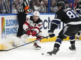 New Jersey Devils center Jack Hughes (86) slips the puck away from Tampa Bay Lightning defenseman Erik Cernak (81) during the first period of an NHL hockey game Saturday, Nov. 16, 2024, in Tampa, Fla. (AP Photo/Chris O'Meara)