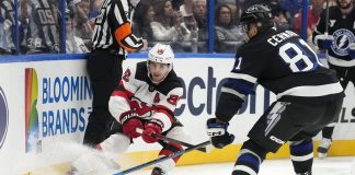 New Jersey Devils center Jack Hughes (86) slips the puck away from Tampa Bay Lightning defenseman Erik Cernak (81) during the first period of an NHL hockey game Saturday, Nov. 16, 2024, in Tampa, Fla. (AP Photo/Chris O'Meara)