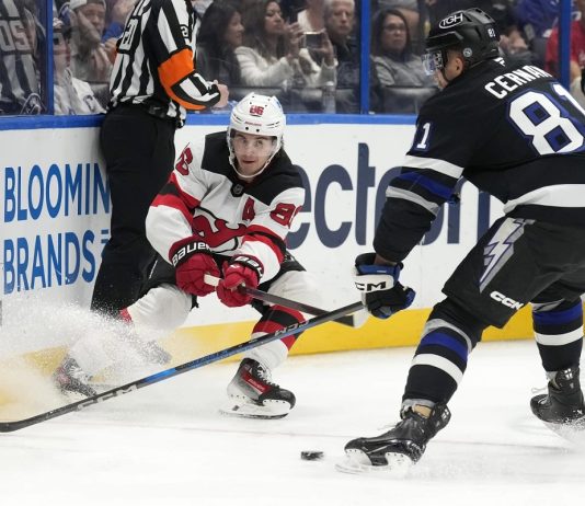 New Jersey Devils center Jack Hughes (86) slips the puck away from Tampa Bay Lightning defenseman Erik Cernak (81) during the first period of an NHL hockey game Saturday, Nov. 16, 2024, in Tampa, Fla. (AP Photo/Chris O'Meara)