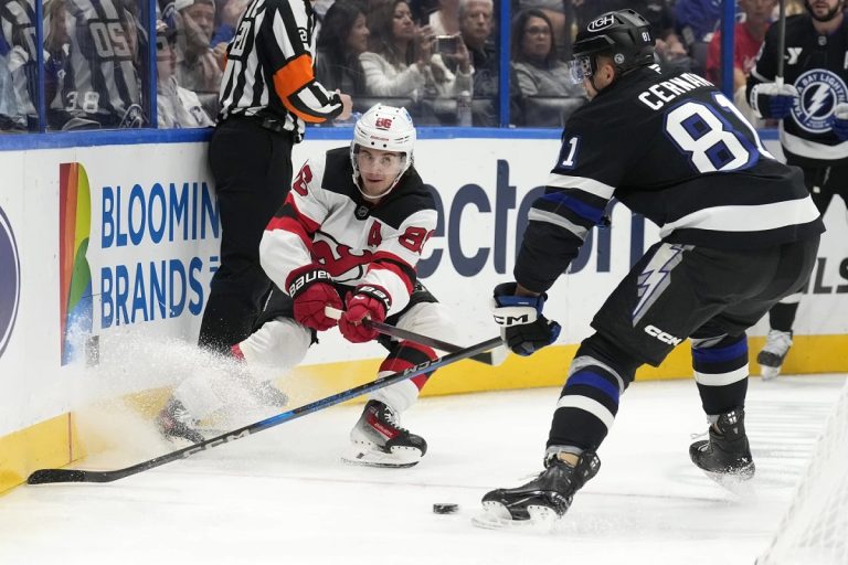 New Jersey Devils center Jack Hughes (86) slips the puck away from Tampa Bay Lightning defenseman Erik Cernak (81) during the first period of an NHL hockey game Saturday, Nov. 16, 2024, in Tampa, Fla. (AP Photo/Chris O'Meara)