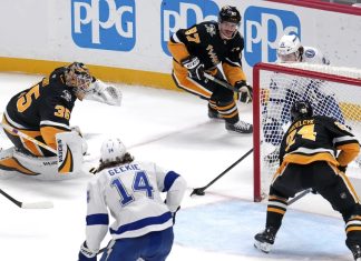 Tampa Bay Lightning's Brayden Point, top right behind goal, gets the game-winning overtime goal past Pittsburgh Penguins goaltender Tristan Jarry (35) and defenders Sidney Crosby (87) and Matt Grzelcyk (24) during an NHL hockey game Tuesday, Nov. 19, 2024, in Pittsburgh. The Lightning won 3-2. (AP Photo/Gene J. Puskar)