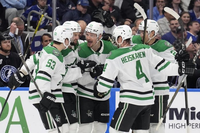 Dallas Stars center Roope Hintz (24) celebrates his goal against the Tampa Bay Lightning with center Wyatt Johnston (53) and defenseman Miro Heiskanen (4) during the third period of an NHL hockey game Saturday, Nov. 23, 2024, in Tampa, Fla. (AP Photo/Chris O'Meara)