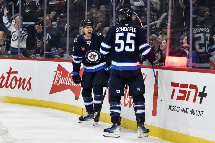 Winnipeg Jets' Mark Scheifele (55) celebrates after his goal against the Tampa Bay Lightning with teammate Gabriel Vilardi (13) during second-period NHL hockey game action in Winnipeg, Manitoba, Sunday, Nov. 3, 2024. (Fred Greenslade/The Canadian Press via AP)