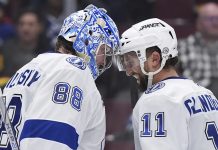 Tampa Bay Lightning goalie Andrei Vasilevskiy (88) and Luke Glendening (11) celebrate after they defeated the Vancouver Canucks in NHL hockey game action in Vancouver, British Columbia, Sunday, Dec. 8, 2024. (Darryl Dyck/The Canadian Press via AP)