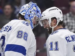 Tampa Bay Lightning goalie Andrei Vasilevskiy (88) and Luke Glendening (11) celebrate after they defeated the Vancouver Canucks in NHL hockey game action in Vancouver, British Columbia, Sunday, Dec. 8, 2024. (Darryl Dyck/The Canadian Press via AP)