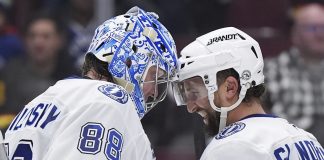 Tampa Bay Lightning goalie Andrei Vasilevskiy (88) and Luke Glendening (11) celebrate after they defeated the Vancouver Canucks in NHL hockey game action in Vancouver, British Columbia, Sunday, Dec. 8, 2024. (Darryl Dyck/The Canadian Press via AP)