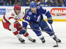 Tampa Bay Lightning center Brayden Point (21) cuts around Carolina Hurricanes left wing Eric Robinson (50) during the second period of an NHL hockey game Tuesday, Jan. 7, 2025, in Tampa, Fla. (AP Photo/Chris O'Meara)