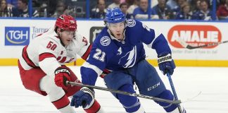 Tampa Bay Lightning center Brayden Point (21) cuts around Carolina Hurricanes left wing Eric Robinson (50) during the second period of an NHL hockey game Tuesday, Jan. 7, 2025, in Tampa, Fla. (AP Photo/Chris O'Meara)