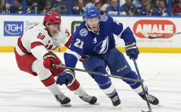 Tampa Bay Lightning center Brayden Point (21) cuts around Carolina Hurricanes left wing Eric Robinson (50) during the second period of an NHL hockey game Tuesday, Jan. 7, 2025, in Tampa, Fla. (AP Photo/Chris O'Meara)