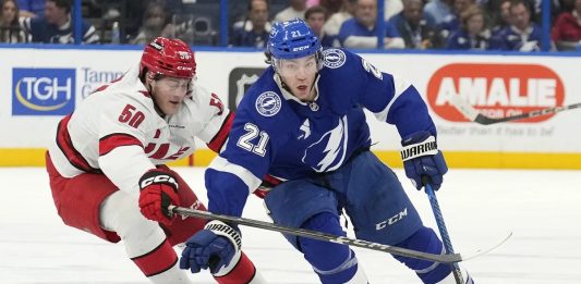 Tampa Bay Lightning center Brayden Point (21) cuts around Carolina Hurricanes left wing Eric Robinson (50) during the second period of an NHL hockey game Tuesday, Jan. 7, 2025, in Tampa, Fla. (AP Photo/Chris O'Meara)