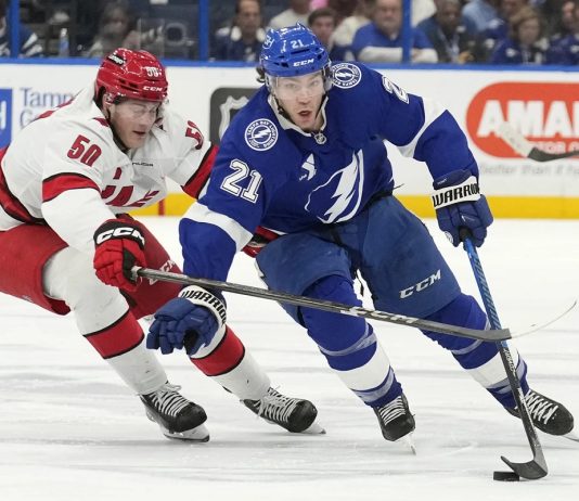 Tampa Bay Lightning center Brayden Point (21) cuts around Carolina Hurricanes left wing Eric Robinson (50) during the second period of an NHL hockey game Tuesday, Jan. 7, 2025, in Tampa, Fla. (AP Photo/Chris O'Meara)