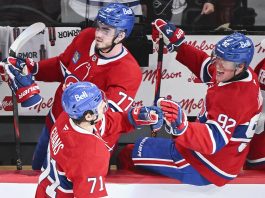 Montreal Canadiens' Jake Evans (71) celebrates with teammates Kirby Dach (77) and Patrik Laine (92) after scoring against the Tampa Bay Lightning during third period NHL hockey action in Montreal, Tuesday, January 21, 2025. (Graham Hughes/The Canadian Press via AP)