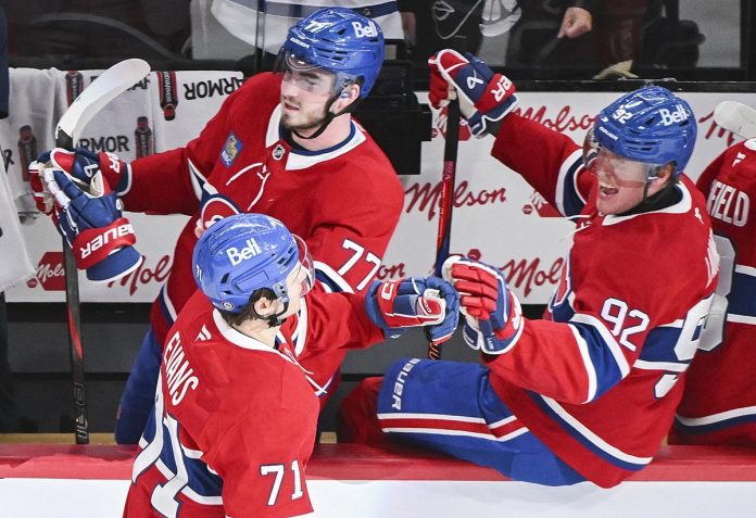 Montreal Canadiens' Jake Evans (71) celebrates with teammates Kirby Dach (77) and Patrik Laine (92) after scoring against the Tampa Bay Lightning during third period NHL hockey action in Montreal, Tuesday, January 21, 2025. (Graham Hughes/The Canadian Press via AP)