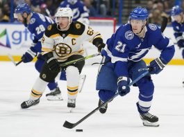 Tampa Bay Lightning center Brayden Point (21) breaks out ahead of Boston Bruins left wing Brad Marchand (63) during the second period of an NHL hockey game Thursday, Jan. 9, 2025, in Tampa, Fla. (AP Photo/Chris O'Meara)