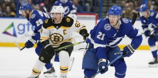 Tampa Bay Lightning center Brayden Point (21) breaks out ahead of Boston Bruins left wing Brad Marchand (63) during the second period of an NHL hockey game Thursday, Jan. 9, 2025, in Tampa, Fla. (AP Photo/Chris O'Meara)