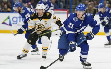 Tampa Bay Lightning center Brayden Point (21) breaks out ahead of Boston Bruins left wing Brad Marchand (63) during the second period of an NHL hockey game Thursday, Jan. 9, 2025, in Tampa, Fla. (AP Photo/Chris O'Meara)