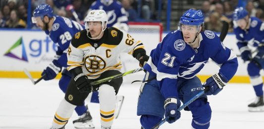 Tampa Bay Lightning center Brayden Point (21) breaks out ahead of Boston Bruins left wing Brad Marchand (63) during the second period of an NHL hockey game Thursday, Jan. 9, 2025, in Tampa, Fla. (AP Photo/Chris O'Meara)