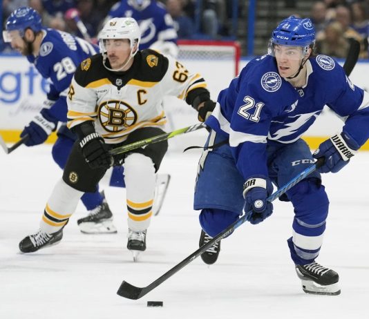 Tampa Bay Lightning center Brayden Point (21) breaks out ahead of Boston Bruins left wing Brad Marchand (63) during the second period of an NHL hockey game Thursday, Jan. 9, 2025, in Tampa, Fla. (AP Photo/Chris O'Meara)