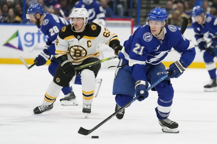 Tampa Bay Lightning center Brayden Point (21) breaks out ahead of Boston Bruins left wing Brad Marchand (63) during the second period of an NHL hockey game Thursday, Jan. 9, 2025, in Tampa, Fla. (AP Photo/Chris O'Meara)