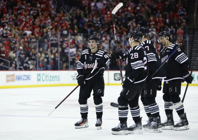 New Jersey Devils center Jack Hughes (86) celebrates with teammates after scoring a goal against the Tampa Bay Lightning during the second period of an NHL hockey game, Saturday, Jan. 11, 2025, in Newark, N.J. (AP Photo/Noah K. Murray)