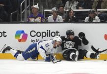 Tampa Bay Lightning center Luke Glendening, left, and Los Angeles Kings defenseman Vladislav Gavrikov fall as they vie for the puck during the first period of an NHL hockey game, Saturday, Jan. 4, 2025, in Los Angeles. (AP Photo/Mark J. Terrill)