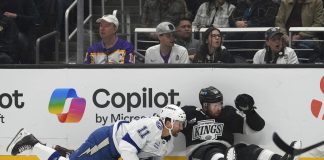 Tampa Bay Lightning center Luke Glendening, left, and Los Angeles Kings defenseman Vladislav Gavrikov fall as they vie for the puck during the first period of an NHL hockey game, Saturday, Jan. 4, 2025, in Los Angeles. (AP Photo/Mark J. Terrill)