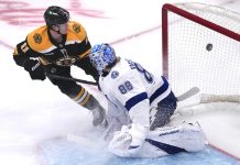 Boston Bruins center Trent Frederic (11) flips the puck past Tampa Bay Lightning goaltender Andrei Vasilevskiy (88) for a goal during the first period of an NHL hockey game, Tuesday, Jan. 14, 2025, in Boston. (AP Photo/Charles Krupa)