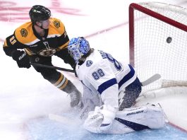 Boston Bruins center Trent Frederic (11) flips the puck past Tampa Bay Lightning goaltender Andrei Vasilevskiy (88) for a goal during the first period of an NHL hockey game, Tuesday, Jan. 14, 2025, in Boston. (AP Photo/Charles Krupa)