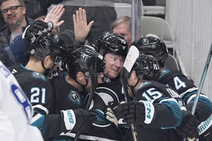 San Jose Sharks center Tyler Toffoli, center, celebrates with teammates after scoring a gaol against the Tampa Bay Lightning during the first period of an NHL hockey game in San Jose, Calif., Thursday, Jan. 2, 2025. (AP Photo/Tony Avelar)