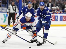 Edmonton Oilers center Connor McDavid (97) gets around Tampa Bay Lightning left wing Brandon Hagel (38) during the third period of an NHL hockey game Tuesday, Feb. 25, 2025, in Tampa, Fla. (AP Photo/Chris O'Meara)