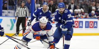 Edmonton Oilers center Connor McDavid (97) gets around Tampa Bay Lightning left wing Brandon Hagel (38) during the third period of an NHL hockey game Tuesday, Feb. 25, 2025, in Tampa, Fla. (AP Photo/Chris O'Meara)