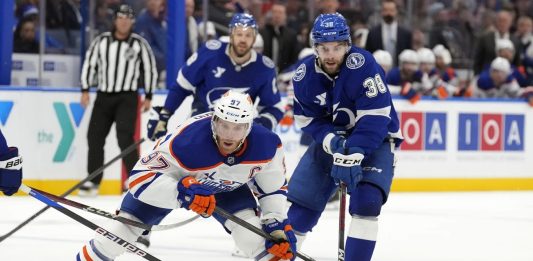 Edmonton Oilers center Connor McDavid (97) gets around Tampa Bay Lightning left wing Brandon Hagel (38) during the third period of an NHL hockey game Tuesday, Feb. 25, 2025, in Tampa, Fla. (AP Photo/Chris O'Meara)