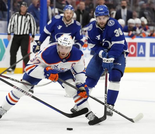 Edmonton Oilers center Connor McDavid (97) gets around Tampa Bay Lightning left wing Brandon Hagel (38) during the third period of an NHL hockey game Tuesday, Feb. 25, 2025, in Tampa, Fla. (AP Photo/Chris O'Meara)