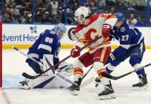 Tampa Bay Lightning goaltender Andrei Vasilevskiy (88) and defenseman Ryan McDonagh (27) team up to stop a shot by Calgary Flames right wing Matt Coronato (27, center) during the first period of an NHL hockey game Thursday, Feb. 27, 2025, in Tampa, Fla. (AP Photo/Chris O'Meara)