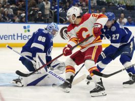 Tampa Bay Lightning goaltender Andrei Vasilevskiy (88) and defenseman Ryan McDonagh (27) team up to stop a shot by Calgary Flames right wing Matt Coronato (27, center) during the first period of an NHL hockey game Thursday, Feb. 27, 2025, in Tampa, Fla. (AP Photo/Chris O'Meara)