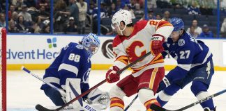 Tampa Bay Lightning goaltender Andrei Vasilevskiy (88) and defenseman Ryan McDonagh (27) team up to stop a shot by Calgary Flames right wing Matt Coronato (27, center) during the first period of an NHL hockey game Thursday, Feb. 27, 2025, in Tampa, Fla. (AP Photo/Chris O'Meara)