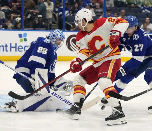 Tampa Bay Lightning goaltender Andrei Vasilevskiy (88) and defenseman Ryan McDonagh (27) team up to stop a shot by Calgary Flames right wing Matt Coronato (27, center) during the first period of an NHL hockey game Thursday, Feb. 27, 2025, in Tampa, Fla. (AP Photo/Chris O'Meara)