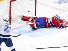 Tampa Bay Lightning's Brayden Point (21) scores against Montreal Canadiens goaltender Jakub Dobes, right, during second-period NHL hockey game action in Montreal, Sunday, Feb. 9, 2025. (Graham Hughes/The Canadian Press via AP)