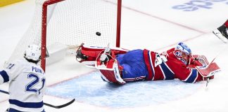 Tampa Bay Lightning's Brayden Point (21) scores against Montreal Canadiens goaltender Jakub Dobes, right, during second-period NHL hockey game action in Montreal, Sunday, Feb. 9, 2025. (Graham Hughes/The Canadian Press via AP)