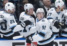 Utah Hockey Club's Logan Cooley (92) celebrates after his goal against the Vancouver Canucks with teammates during the third period of an NHL hockey game in Vancouver, British Columbia, Sunday, March 16, 2025. (Ethan Cairns/The Canadian Press via AP)