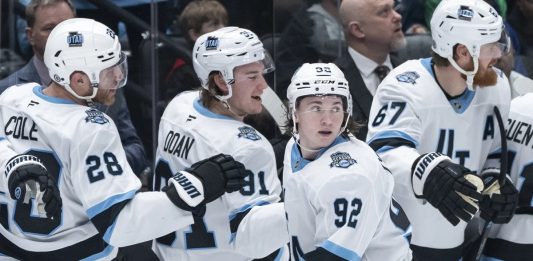 Utah Hockey Club's Logan Cooley (92) celebrates after his goal against the Vancouver Canucks with teammates during the third period of an NHL hockey game in Vancouver, British Columbia, Sunday, March 16, 2025. (Ethan Cairns/The Canadian Press via AP)